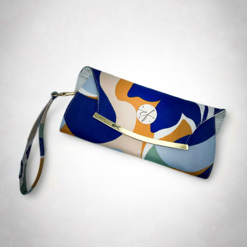 Un portefeuille pochette confectionné à partir d'une écharpe colorée avec un motif floral moderne et abstrait en blanc, bleu, sauge, beige et cannelle. À l'intérieur, on retrouve du similicuir blanc et un popeline brillant de couleur sauge claire.